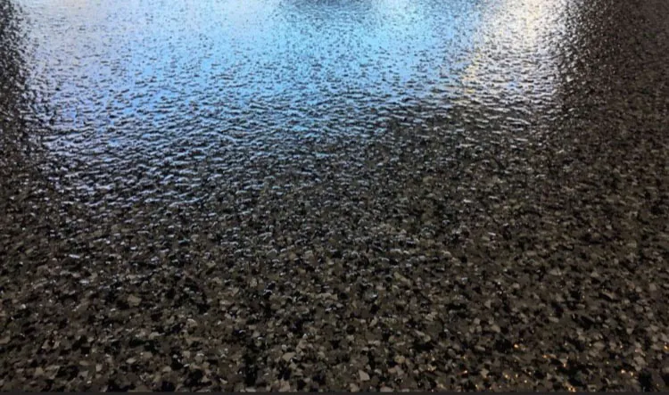Dark flake epoxy floor close-up with glossy finish