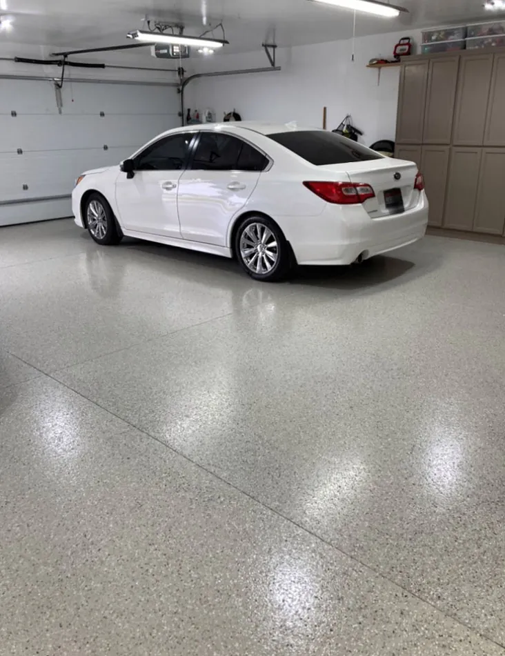 Solid light gray epoxy garage floor with a car parked