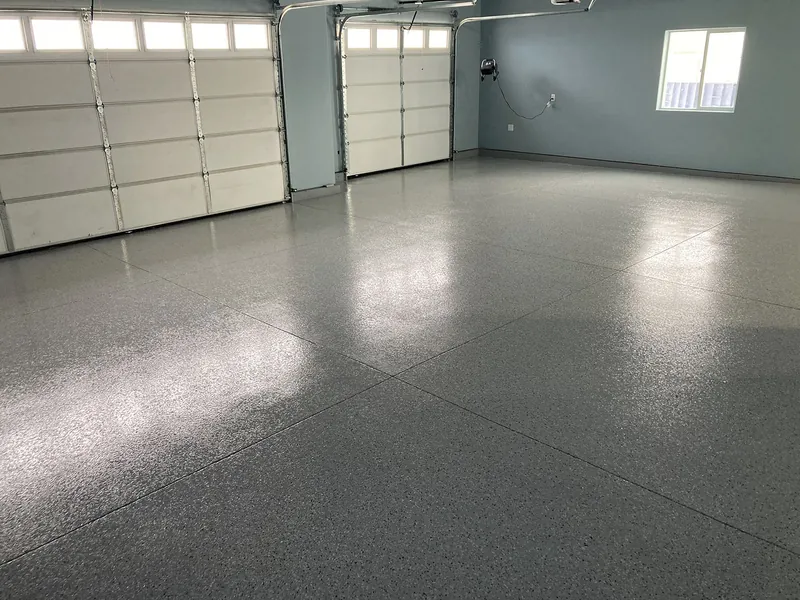 Three-car garage with light gray flake epoxy floor and polyaspartic topcoat