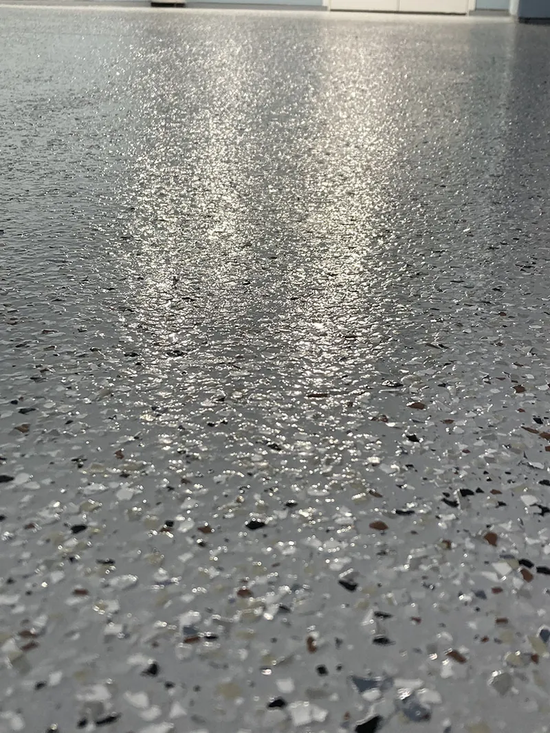 Close-up of gray flake epoxy floor with glossy topcoat